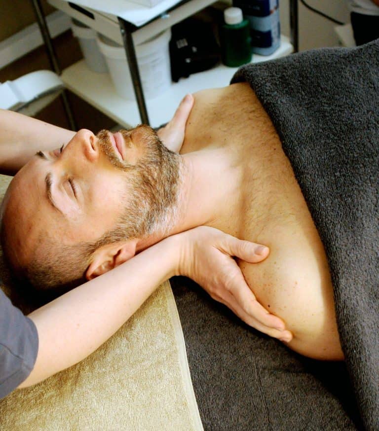 homme sur table de massage recevant un massage sportif